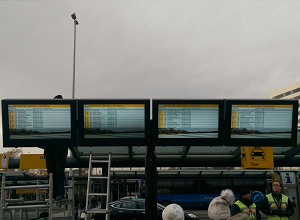 Four portrait weatherproof airport digital signage enclosures at a bus stop