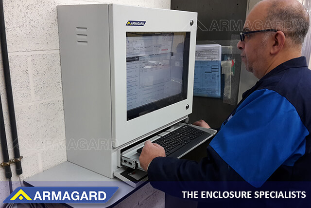 An industrial worker using an IP54 shop-floor computer workstation